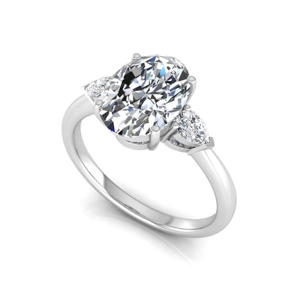 Oval three stone lab grown diamond engagement ring featuring a 1.86 carat IGI certified oval cut center diamond with pear cut side diamonds in a white gold design.