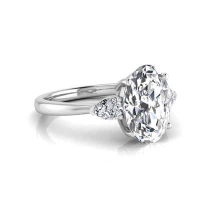 Oval three stone lab grown diamond engagement ring featuring a 1.86 carat IGI certified oval cut center diamond with pear cut side diamonds in a white gold design.