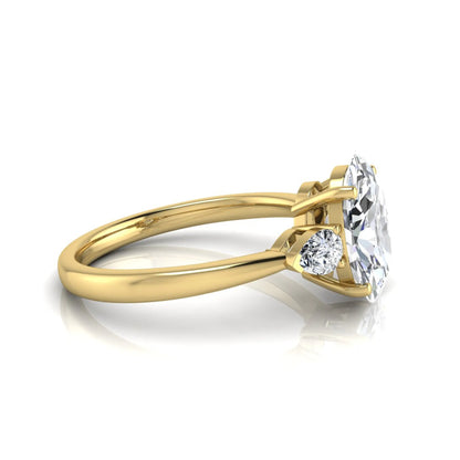 Oval three stone lab grown diamond engagement ring featuring a 1.86 carat IGI certified oval cut center diamond with pear cut side diamonds in a yellow gold design.