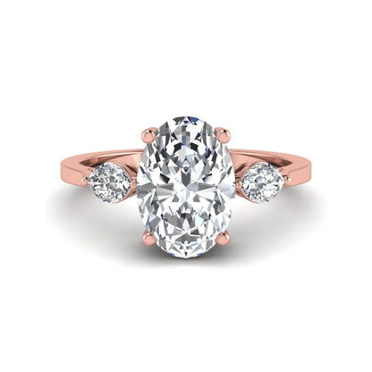 Oval cut lab grown diamond three stone engagement ring with marquise side diamonds in a prong setting featuring a rose gold tone design.