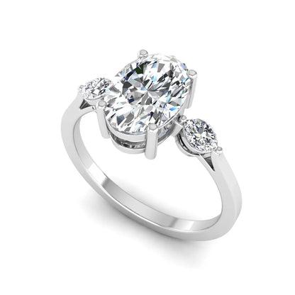 Oval cut lab grown diamond three stone engagement ring with marquise side diamonds in a prong setting featuring a white gold tone design.