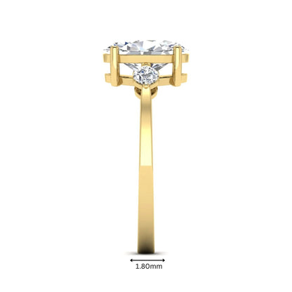 Oval cut lab grown diamond three stone engagement ring with marquise side diamonds in a prong setting featuring a yellow gold tone design.