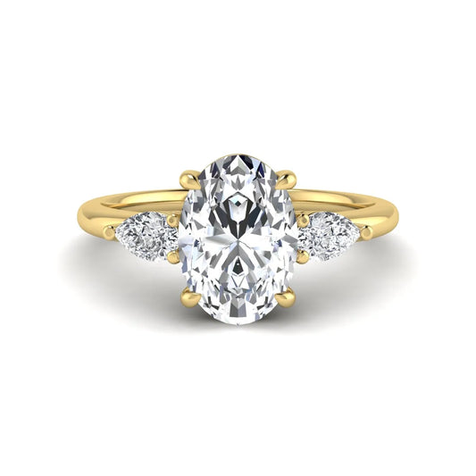 Oval cut lab grown diamond three stone engagement ring with pear side diamonds in a prong setting featuring a yellow gold tone design.