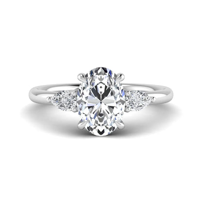 Oval cut lab grown diamond three stone engagement ring with pear cut side diamonds in a prong setting on a polished white gold band.
