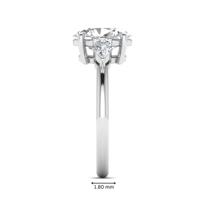 Oval cut lab grown diamond three stone engagement ring with pear cut side diamonds in a prong setting on a polished white gold band.