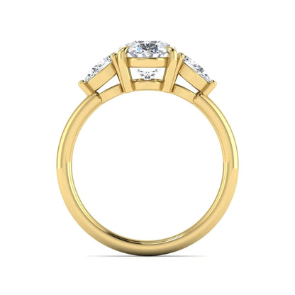 Oval cut lab grown diamond three stone engagement ring with pear cut side diamonds in a prong setting on a polished yellow gold band.