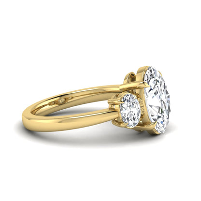 Oval three stone prong set lab grown diamond engagement ring featuring a 3.00 carat oval center diamond with matching oval side diamonds in yellow gold finish.
