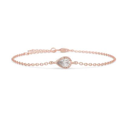 Pear cut lab grown diamond bezel set solitaire bracelet with delicate chain and lobster clasp in rose gold tone.