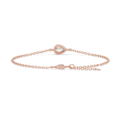 Pear cut lab grown diamond bezel set solitaire bracelet with delicate chain and lobster clasp in rose gold tone.
