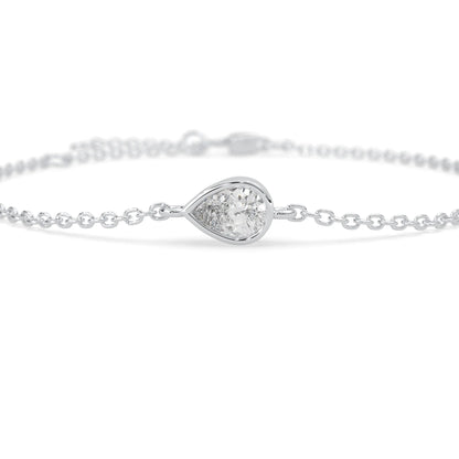 Pear cut lab grown diamond bezel set solitaire bracelet with delicate chain and lobster clasp in white gold tone.