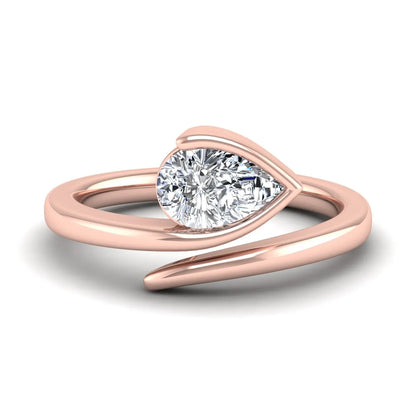 Pear cut lab grown diamond bypass engagement ring featuring a 1.00 carat IGI certified diamond in a modern partial bezel setting with a rose gold design.