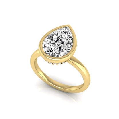 Pear cut lab grown diamond engagement ring featuring a 1.80 carat IGI certified diamond in a bezel setting with a hidden halo of round diamonds on a yellow gold band.
