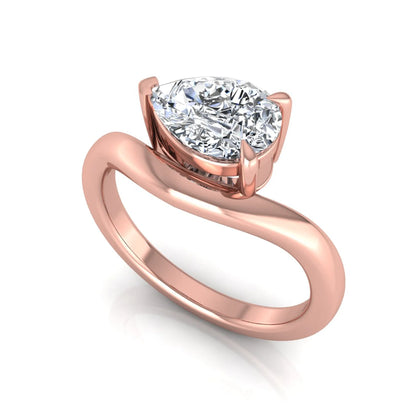 Pear cut lab grown diamond curved solitaire engagement ring in rose gold with a sculpted curved band and IGI certified center diamond.