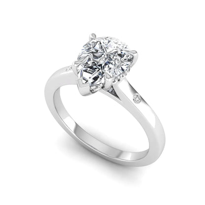 Pear cut lab grown diamond engagement ring with hidden halo and flush set round accent diamonds in white gold featuring a 1.75 carat IGI certified center diamond.