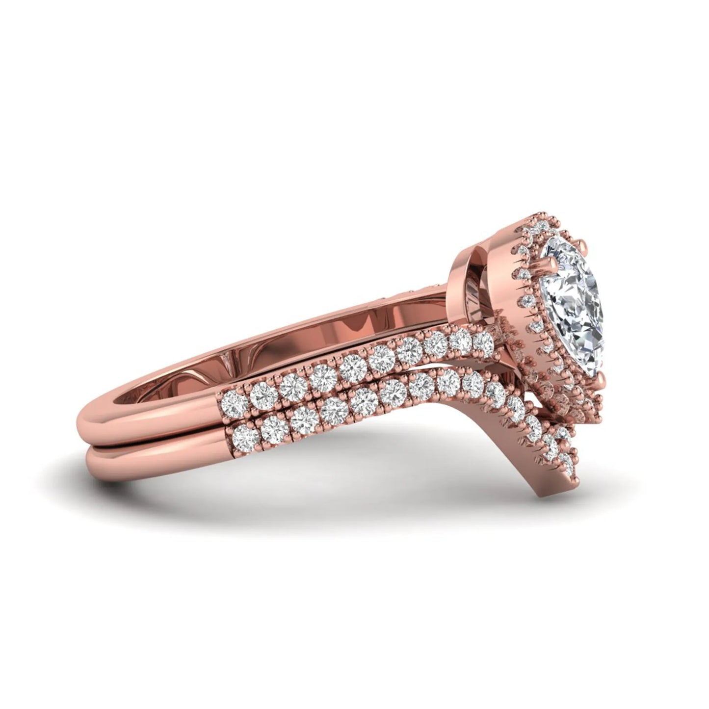 Pear cut lab grown diamond bridal ring set featuring a halo engagement ring with a matching curved pavé wedding band in a rose gold tone design.