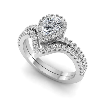 Pear cut lab grown diamond bridal ring set featuring a halo engagement ring with a matching curved pavé wedding band in a white gold tone design.
