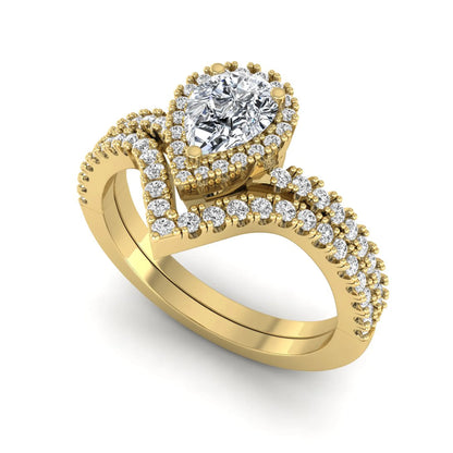 Pear cut lab grown diamond bridal ring set featuring a halo engagement ring with a matching curved pavé wedding band in a yellow gold tone design.