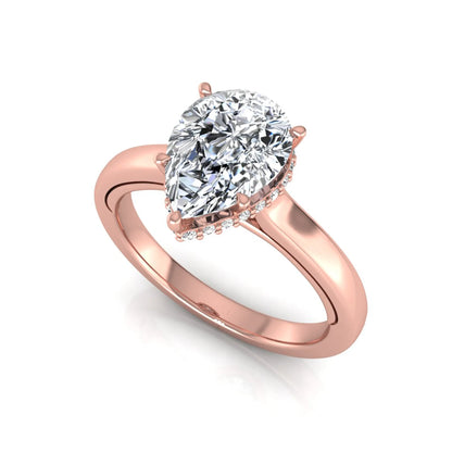 Pear cut lab grown diamond engagement ring featuring a hidden halo of round diamonds in a six-prong setting with a polished rose gold tone band.
