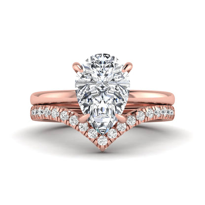 Pear cut lab grown diamond hidden halo solitaire bridal ring set featuring a four-prong engagement ring with a matching pavé chevron wedding band in rose gold.