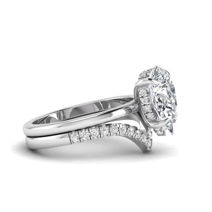 Pear cut lab grown diamond hidden halo solitaire bridal ring set featuring a four-prong engagement ring with a matching pavé chevron wedding band in white gold.