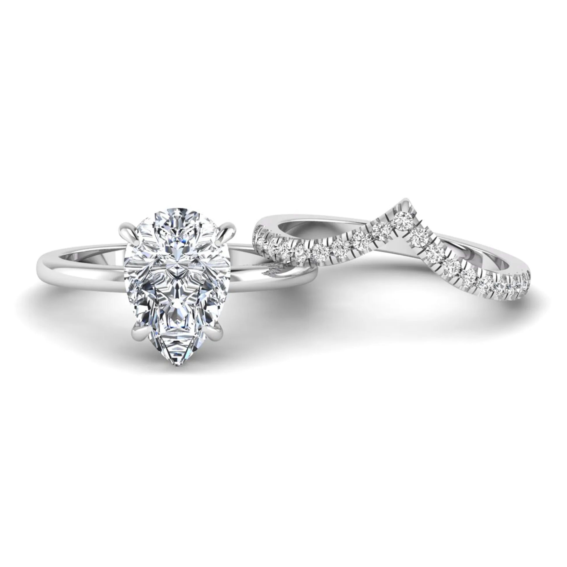 Pear cut lab grown diamond hidden halo solitaire bridal ring set featuring a four-prong engagement ring with a matching pavé chevron wedding band in white gold.