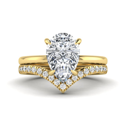 Pear cut lab grown diamond hidden halo solitaire bridal ring set featuring a four-prong engagement ring with a matching pavé chevron wedding band in yellow gold.