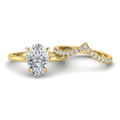 Pear cut lab grown diamond hidden halo solitaire bridal ring set featuring a four-prong engagement ring with a matching pavé chevron wedding band in yellow gold.