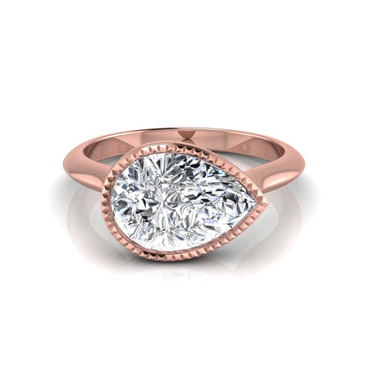 Pear cut lab grown diamond solitaire engagement ring featuring a milgrain bezel setting with a rose gold tone band.