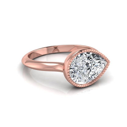 Pear cut lab grown diamond solitaire engagement ring featuring a milgrain bezel setting with a rose gold tone band.