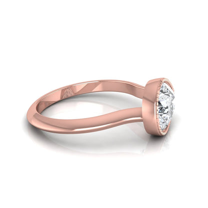 Pear cut lab grown diamond solitaire engagement ring featuring a milgrain bezel setting with a rose gold tone band.