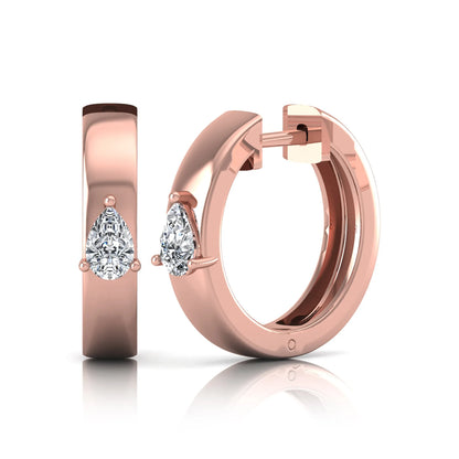 Pear cut lab grown diamond huggie hoop earrings with prong setting and hinged snap closure shown in rose gold tone for display.