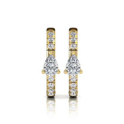 Pear and round cut lab grown diamond pavé huggie hoop earrings featuring a three prong pear diamond center, shared prong round diamond accents, hinged snap closure, and polished yellow gold finish.