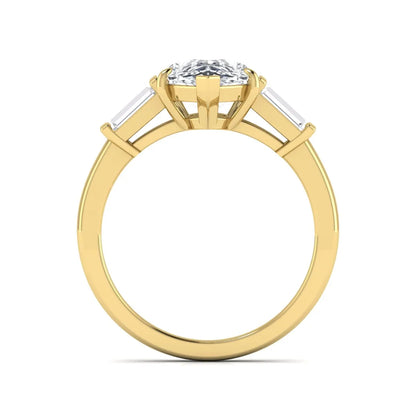Pear cut lab grown diamond three stone engagement ring with baguette side diamonds in a classic prong setting in yellow gold