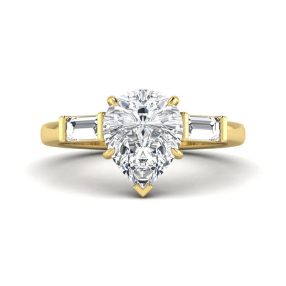 Pear cut lab grown diamond three stone engagement ring with baguette side diamonds in a classic prong setting in yellow gold