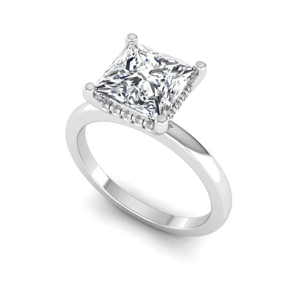 Princess cut lab grown diamond hidden halo solitaire engagement ring with four-prong setting and white gold tone band.