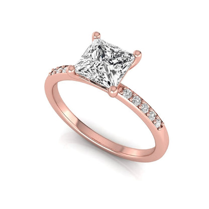 Princess cut lab grown diamond side stone engagement ring featuring a 1.24 carat IGI certified princess cut diamond with pavé round side diamonds in a rose gold setting.