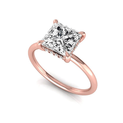 Princess cut lab grown diamond hidden halo solitaire engagement ring with a four-prong setting and rose gold tone band.
