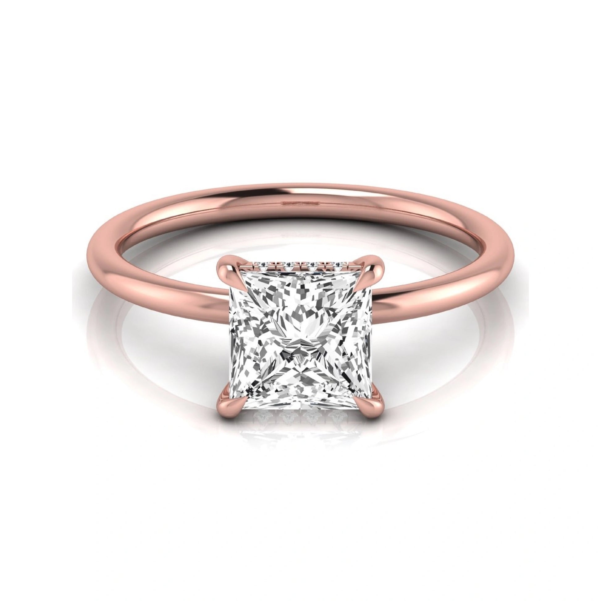 Princess cut lab grown diamond hidden halo solitaire engagement ring with a four-prong setting and rose gold tone band.