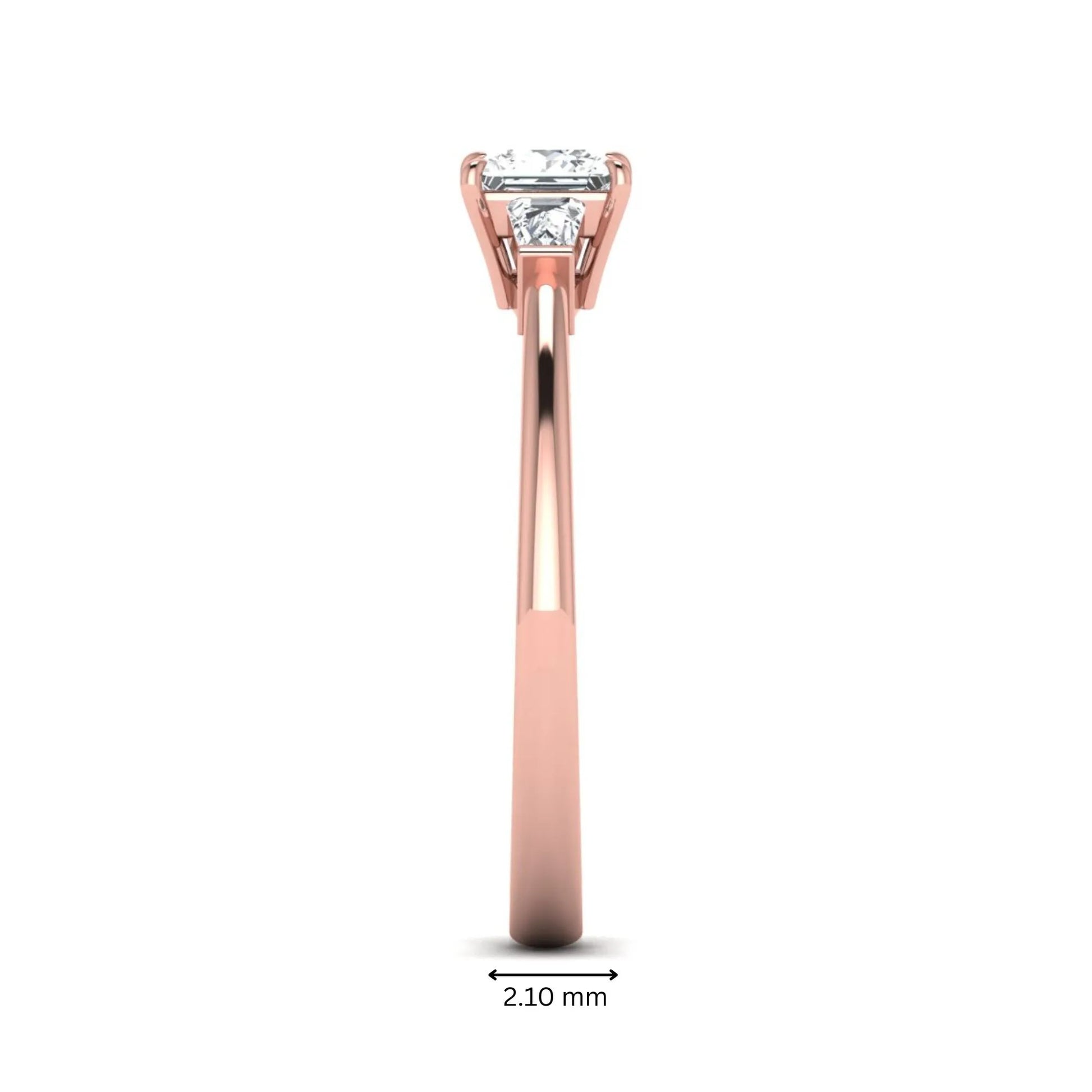 Princess cut lab grown diamond three stone engagement ring with tapered baguette side diamonds in a four-prong setting and rose gold tone band.