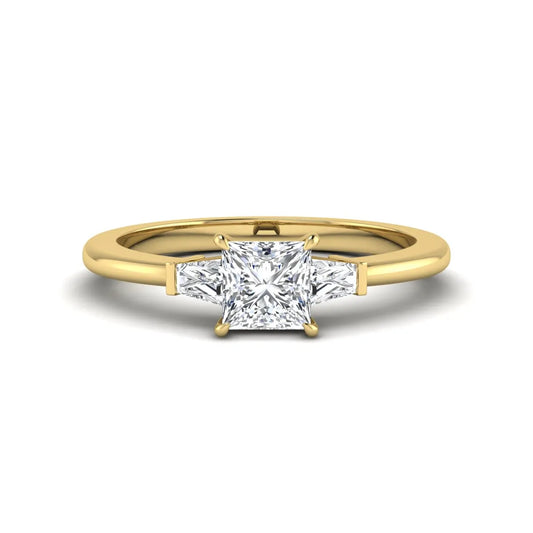 Princess cut lab grown diamond three stone engagement ring with tapered baguette side diamonds in a four-prong setting and yellow gold tone band.
