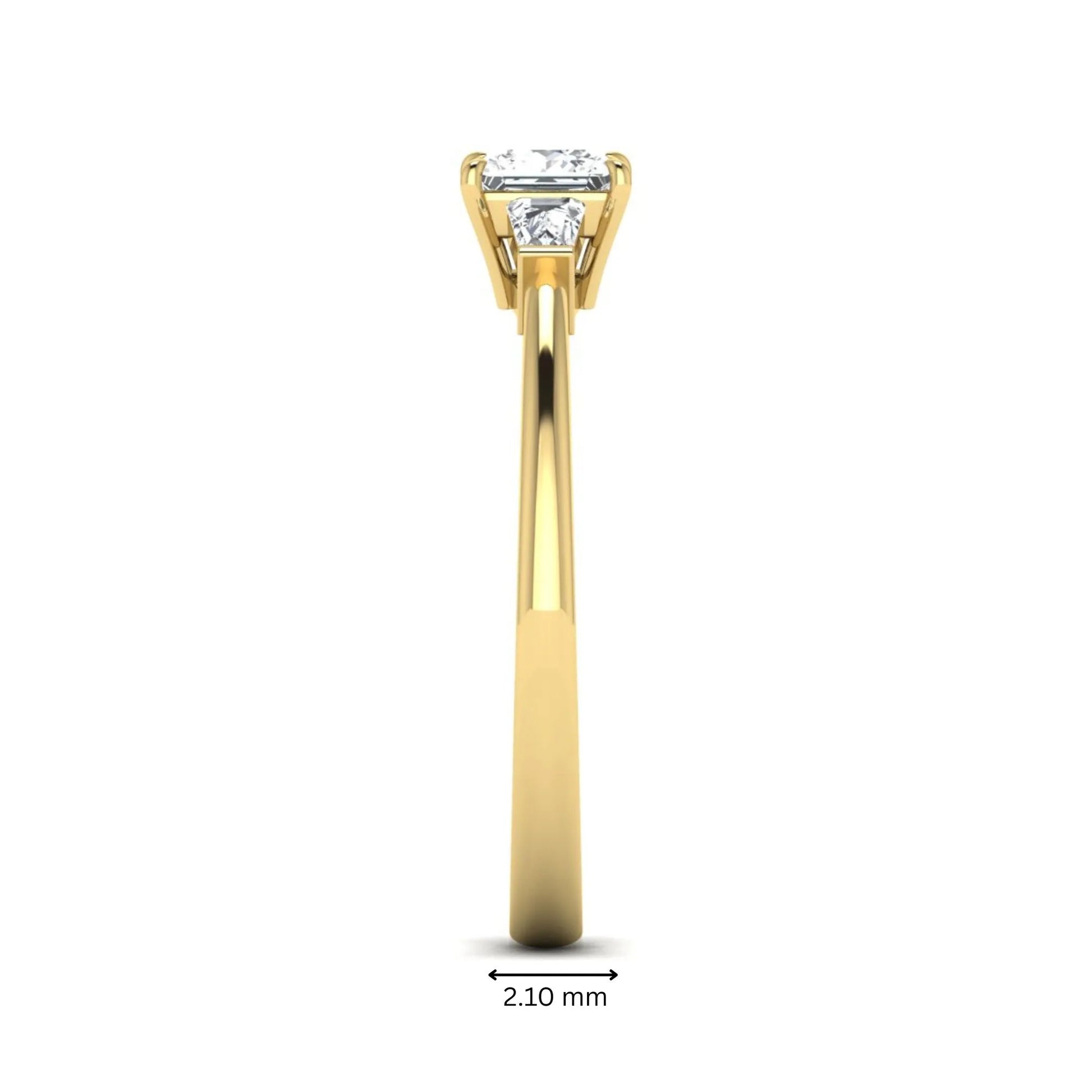 Princess cut lab grown diamond three stone engagement ring with tapered baguette side diamonds in a four-prong setting and yellow gold tone band.