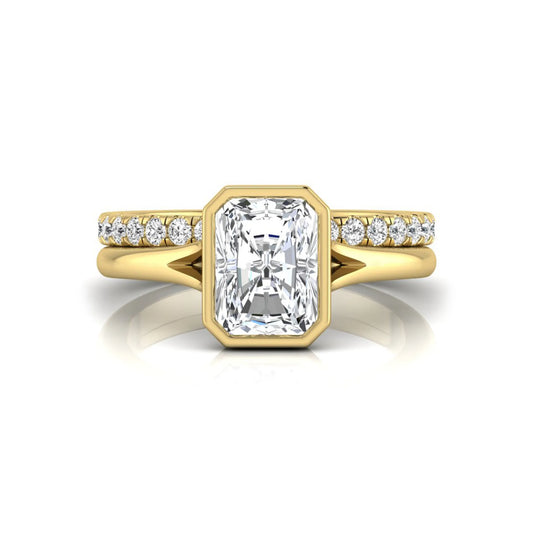 Radiant cut bezel set lab grown diamond bridal ring set with pavé contour band and yellow gold metal tone.