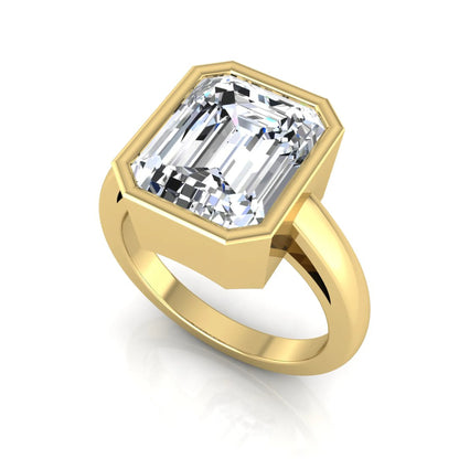 Radiant cut bezel set lab grown diamond solitaire engagement ring with a yellow gold tone band featuring an IGI certified center diamond.