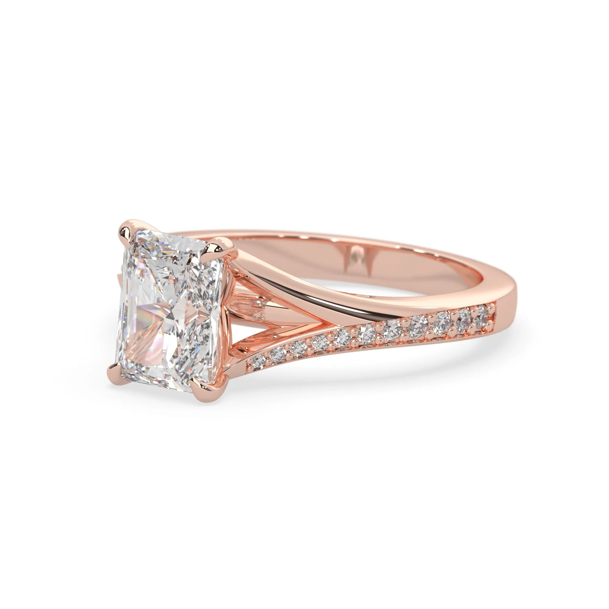 Rose gold ring with an emerald cut lab grown diamond and smaller diamonds on the band against a white background