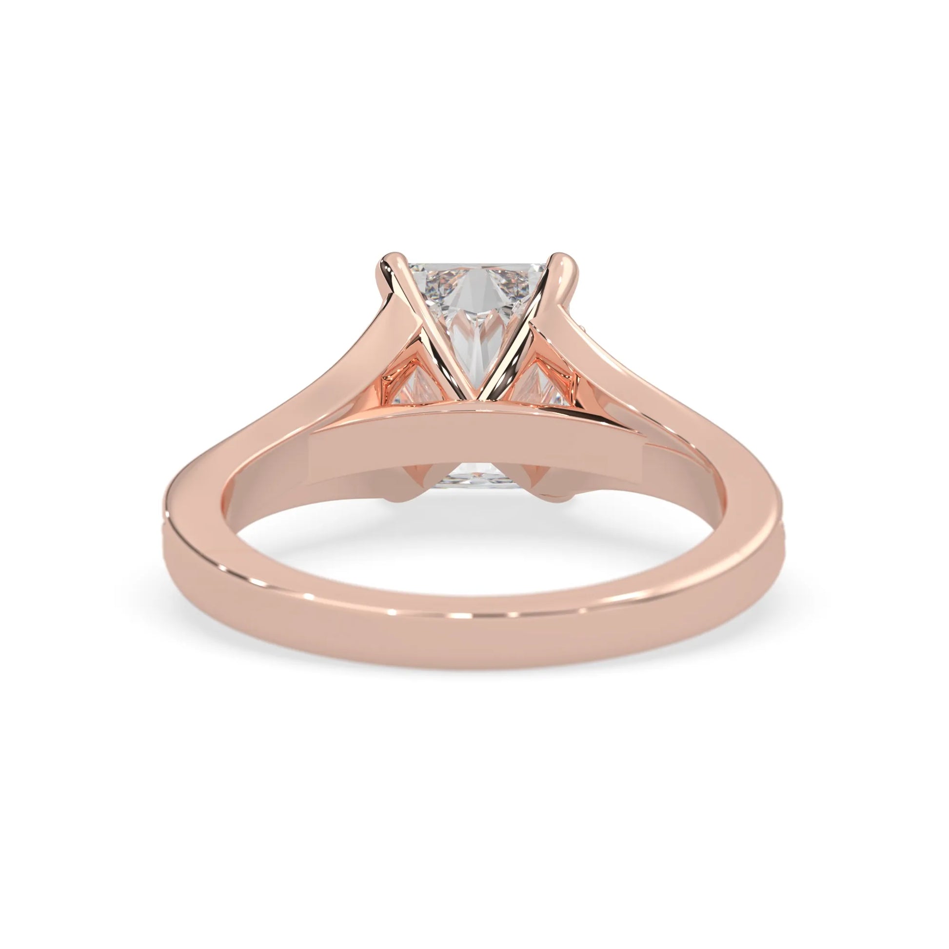 Rose gold ring with an emerald cut lab grown diamond and smaller diamonds on the band against a white background