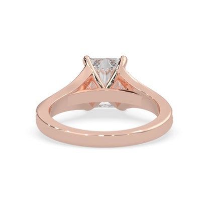 Rose gold ring with an emerald cut lab grown diamond and smaller diamonds on the band against a white background
