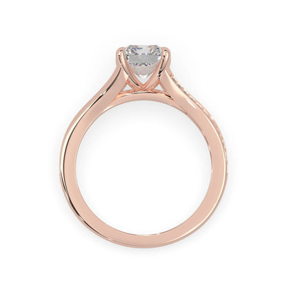 Rose gold ring with an emerald cut lab grown diamond and smaller diamonds on the band against a white background