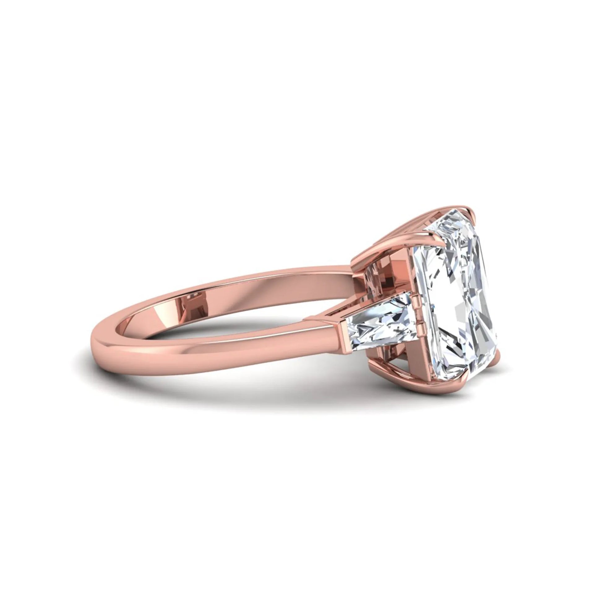 Radiant cut lab grown diamond three stone engagement ring with tapered baguette side diamonds and four prong setting in rose gold tone.