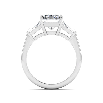 Radiant cut lab grown diamond three stone engagement ring with tapered baguette side diamonds and four prong setting in white gold tone.