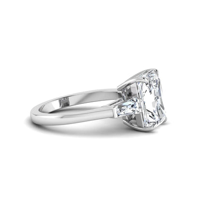 Radiant cut lab grown diamond three stone engagement ring with tapered baguette side diamonds and four prong setting in white gold tone.